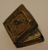 1960-0282-KPO-16-12 a.jpg; 1960-0282-KPO/16-12; Boekje met zilveren boekband uit de salon van het grote poppenhuis.; boeken